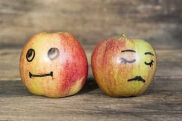 Face on an apples. Apple family mother father and child on wooden background. Room for text 