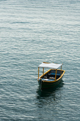Obraz na płótnie Canvas Small boat anchored near shore on calm sea