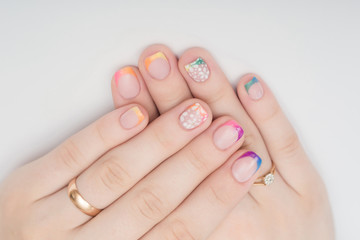 Multi-colored jelly sweets in the hands with a bright nail polish