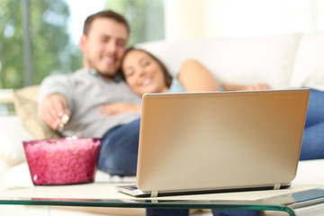 Couple watching tv in a laptop at home