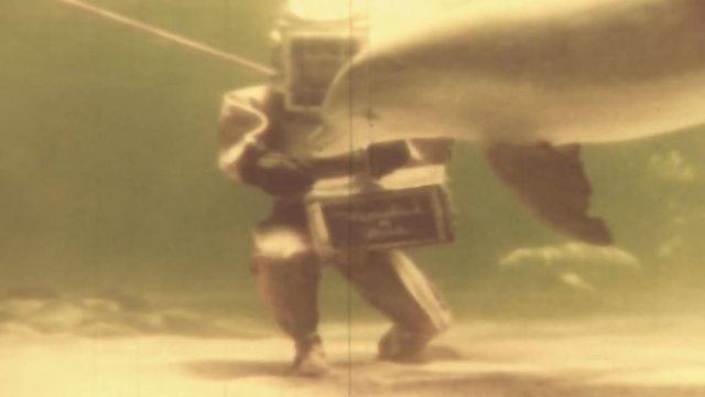 Vintage scuba diver feeding sharks