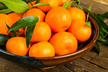 fresh mandarin oranges fruit with leaves on wooden table