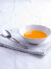 Autumn pumpkin soup on white tablecloth.