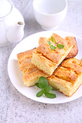 homemade pie with apples and cinnamon is cut slices on a plate, wooden background