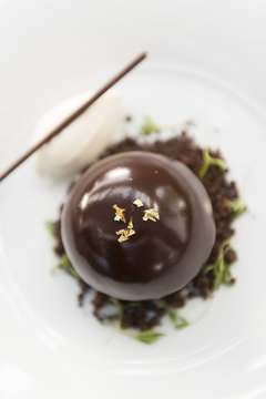 Chocolate bombe dessert served with vanilla ice cream