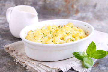 Cauliflower baked with cheese in a white bowl