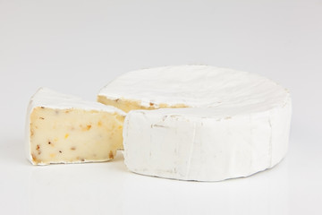 Fresh brie cheese with white mold on a white background