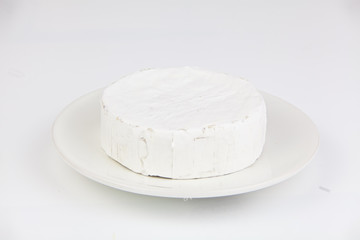 Fresh brie cheese with white mold on a white background