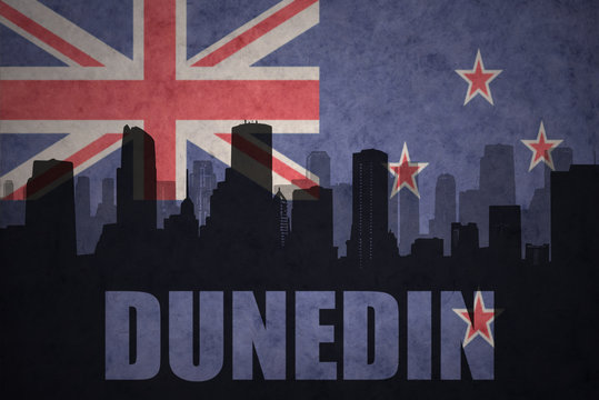 abstract silhouette of the city with text Dunedin at the vintage new zealand flag