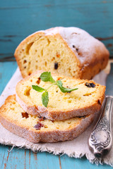 homemade cake with raisins and nuts cut into pieces on a blue background
