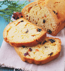 homemade cake with raisins and nuts cut into pieces on a blue background