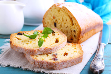 homemade cake with raisins and nuts cut into pieces on a blue background