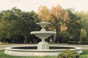 Fototapeta na wymiar Old fountain in autumn park.