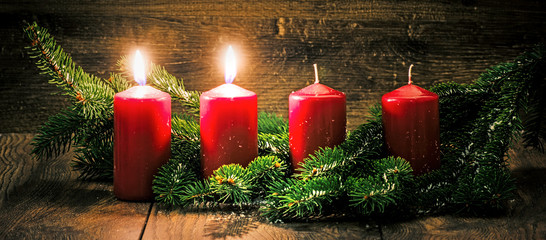 Zweiter Advent: zwei leuchtende Kerzen vor einem Holzhintergund - 125646519
