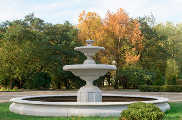 Old fountain in autumn park.