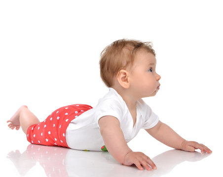 Four month Infant child baby girl lying in red pants on a floor