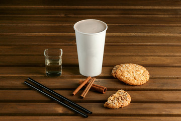 Coffee in a white cup, cookies are close, on a light wooden table