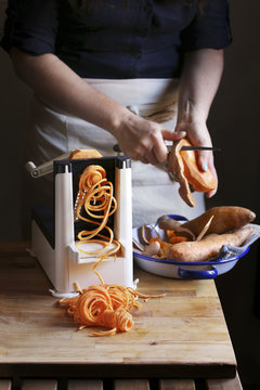 Woman making sweet potato noodle with a spiralizer machine