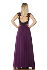 Fototapeta premium back view of pretty woman standing in a long dress