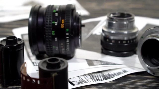 Vintage 35mm cameras, lenses, photos and film are piled up.