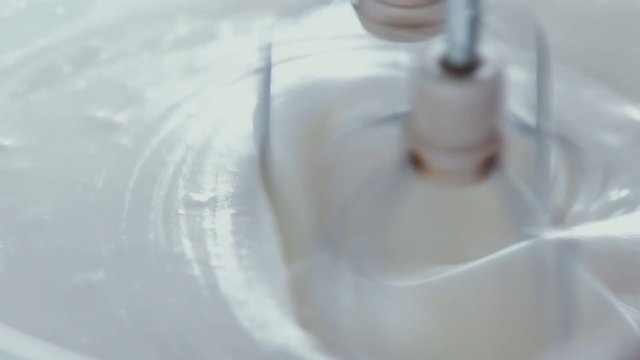 Close up: Whisks whipped egg whites and sugar in the bowl of glass. Whisk in glass bowl of raw egg in slow motion. Whisk for whipping. Slow motion of flan cooking. Cooking Pancake Batter