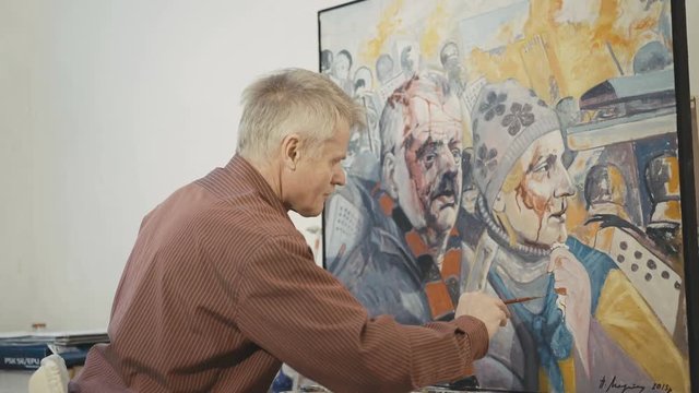 Old painter draws the crying woman and man on the Kyiv's area in 4K