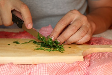 Unrecognizable man cutting parsley. Selective focus. 