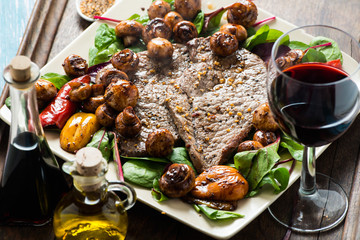 Frying beef steak with mushrooms and baby leaf salad