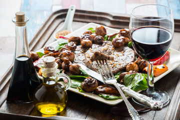 Frying beef steak with mushrooms and baby leaf salad