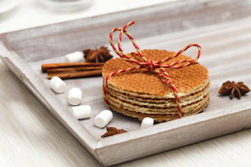 A pack of caramel wafers on wooden tray with seasonings