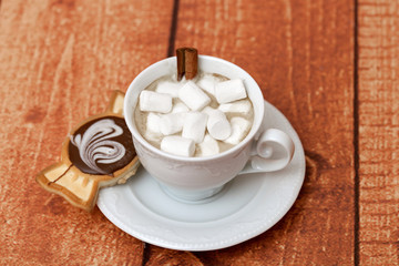 Cup of cocoa with cinnamon, marshmallows and biscuits