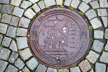 Sewer manhole on stone pavement of Trondheim.