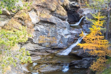 Fototapeta premium waterfall in the mountains and the autumnal trees, long exposure