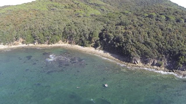 This video is about Vista aerea  della costa toscana con nuotatore