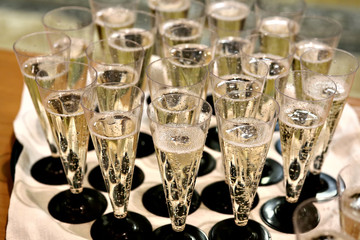 Champagne poured into glasses. Many glasses of champagne on the table. The bubbles in champagne. The reception on the occasion.
