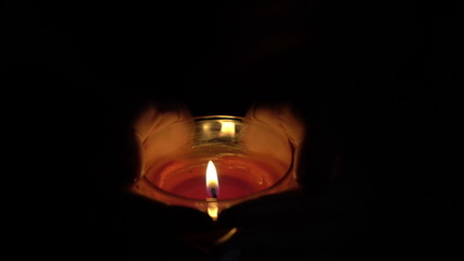 burning candle in the hands of women.