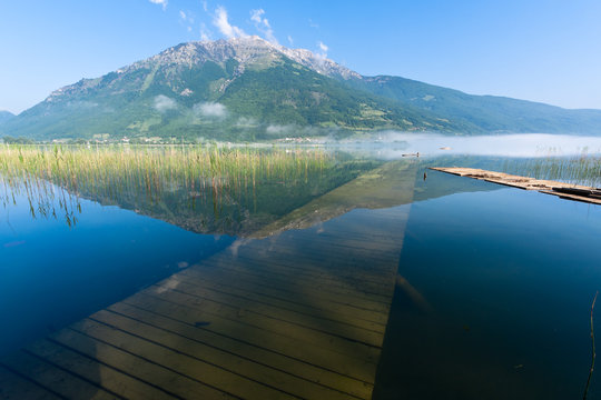 Pier under and one above the water surface of a folding Plav lake, Montenegro