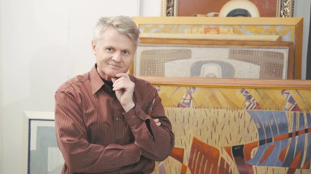 Portrait of the old gray man smiling and looking on camera in pose 4K