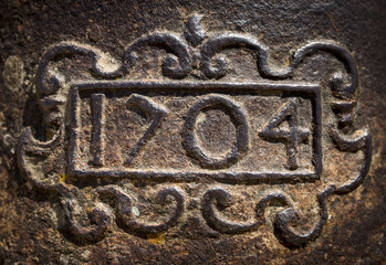 year 1704 carved on a rusty iron surface