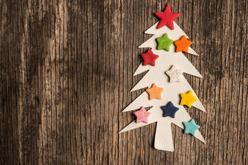 Christmas tree made of paper and stars on wooden background