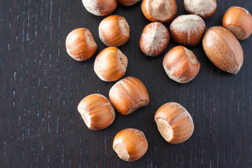 Overhead view of hazlenuts on a dark wooden surface