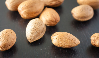 Almonds in the shell on a dark wooden surface