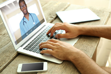 Man video chatting with doctor on laptop. Professional medical online consultation concept.