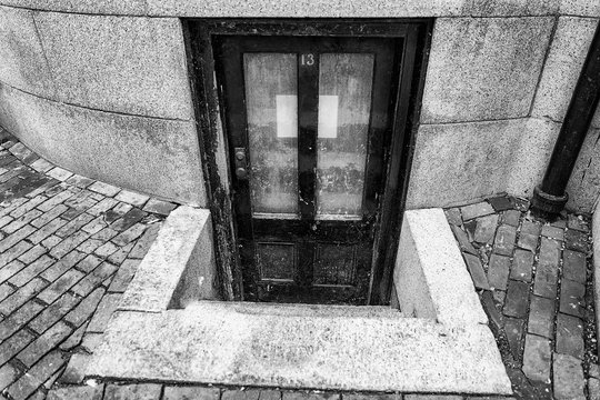 number 13 on the door. old worn door to the apartment in the basement. the concept of horror, mysticism and mystery. triskaidekaphobia and paraskavedekatriaphobia. 