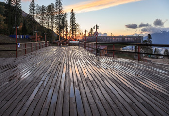 Wooden observation platform on a cableway lift station in autumn mountains at sunset scenery