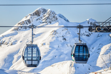 Cableway lift gondola cabins on winter snowy mountains background scenery © Wilding