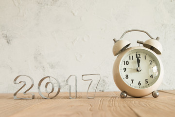 New Year 2017 and alarm clock on a wood