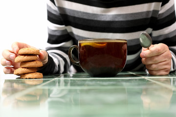 hands of a man with a cup of tea and biscuits