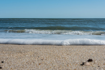 Obraz premium White foam washing ashore on a tropical beach