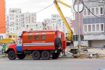 fire truck with the words "technical service" in Russian near a house under construction